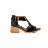 Sandalias de cuero color negro con acabado charol, taco cuadrado de madera, puntera abierta y tira ajustable con hebilla metálica en el tobillo.