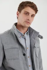 Sobretodo de paño casual color negro, con abotonadura frontal, bolsillos frontales con solapa, cuello alto y detalles de presillas en los hombros.
