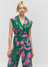 Mono largo con estampado tropical en tonos verdes y rosados, cuello con solapas, sin mangas y cinturón desmontable con hebilla forrada. Cierre con botones en el cuello.