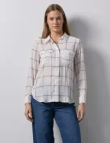 Camisa de gasa estampada, marca Tahari. Cuello a la base con solapa y apertura central con botones. Delantera con bolsillos aplicados. Manga larga con puño y botón.