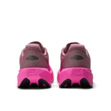 Championes de running New Balance modelo FuelCell Rebel v5, con diseño aerodinámico en tonos fucsia y violeta. Presentan entresuela FuelCell de espuma reactiva, parte superior de malla transpirable con tecnología FantomFit y suela con refuerzo de goma en la parte delantera.