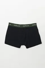 Boxer de algodón color negro, con pretina elástica de color verde oscuro que lleva la inscripción "Uniform" en blanco.