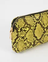 Estuche pequeño amarillo con estampado de piel de serpiente y cierre dorado.