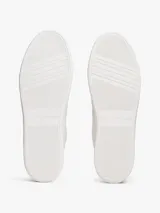 Zapatillas de corte bajo Tommy Hilfiger, confeccionadas en piel napa blanca con paneles de textura contrastante en el talón. Presentan suela gruesa de goma, cierre con cordones y logo metálico en bajo relieve en el lateral.