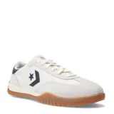 Championes Converse Run Star Trainer OX, de diseño urbano con capellada de tela y refuerzos de gamuza en tono crema. Presenta el logo de estrella y chevron en color negro en el lateral, con suela de goma color caramelo y detalle en el talón.