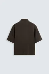 Camisa de corte relajado confeccionada en tejido con mezcla de modal, con cuello solapa, manga corta y cierre frontal de botones.