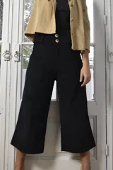 Pantalón marrón de pana con corte cropped y bolsillos frontales.