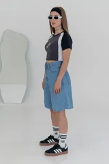 Bermuda de jean celeste, de corte amplio y largo hasta la rodilla.