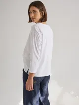 Remera de silueta relajada con cortes geométricos en el frente y costuras a la vista en tono contrastante. Presenta cuello redondo y mangas largas.