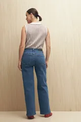 Jean de corte recto confeccionado en denim con spandex, de tiro medio y color azul claro. Presenta un tajo lateral en el ruedo de ambas piernas.
