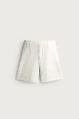Bermuda regular fit color blanco confeccionada en lino, con bolsillos frontales, bolsillos traseros de doble vivo con botón y cierre frontal con cremallera y botón.