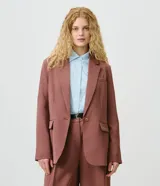 Blazer de sastrería color marrón, de modelaje comfort, corte estructurado y largo medio. Cuenta con cuello con solapa, cierre frontal de botón único, bolsillos con tapa y mangas largas.