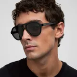 Lentes de sol estilo aviador con montura robusta de color negro y doble puente. Presentan lentes polarizadas oscuras con protección UV400.