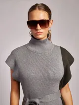 Vestido midi de tejido acanalado con cuello alto, sin mangas y diseño bicolor en tonos beige y terracota. Incluye un lazo ajustable en la cintura para entallar la silueta.