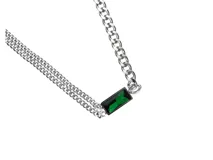 Collar de acero plateado con cadena de eslabones y dije rectangular con cristal verde esmeralda. El largo del collar es de 40cm más 5cm de alargue y el dije mide 1.8cm x 1cm.