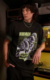 Remera de algodón premium con calce oversize, cuello redondo y mangas cortas. Presenta un estampado gráfico frontal con temática de Daft Punk en tonos verdes y negros.