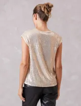 Blusa sin mangas con escote en V, confeccionada completamente en lentejuelas color dorado. Cuenta con forro interno a tono y un corte recto y holgado.