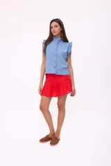 Blusa celeste de denim con cuello mao con volados, mangas cortas con volados y cierre frontal con botones.