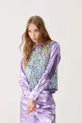 Chaleco capitoneado con estampado floral y terminación metálica.