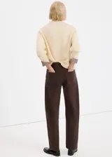 Jeans rectos tiro medio color marrón oscuro con bolsillos clásicos y cierre frontal.