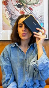 Billetera mediana de diseño rectangular, color negro con bordes en tono suela. Cuenta con cierre perimetral metálico y logo de la marca estampado en el frente.