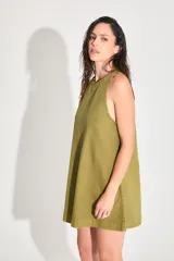Vestido corto de gabardina color verde oliva, con escote cerrado y silueta amplia.