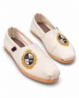 Alpargata de lona color beige, con suela de goma y detalle de escudo bordado en la parte frontal.