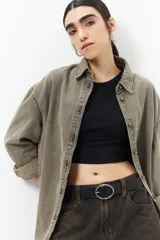 Camisa de jean celeste de manga larga, con botones marrones y corte holgado.