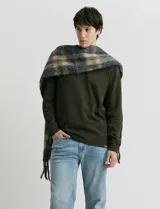 Remera de manga larga con cuello polo, confeccionada en tejido de punto canalé francés. Presenta abotonadura frontal con botones de madera y detalles a contratono en la cartera y el interior del cuello.