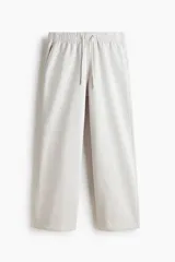 Pantalón deportivo en felpa pesada de mezcla de algodón, color gris claro, de corte holgado con cintura elástica ajustable mediante cordón y bolsillos laterales.