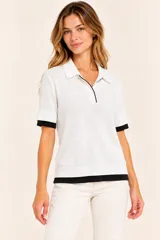 Remera polo de punto color blanco con detalles en negro en el cuello, la botonera, los puños y el ruedo, de manga corta y calce clásico.