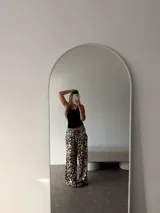 Pantalón negro de algodón y viscosa, con estampado de lunares blancos y corte holgado.