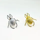 Anillo con forma de escarabajo, realizado en aleación de metal color dorado.