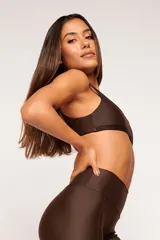 Top deportivo color verde oscuro, con tirantes finos y espalda descubierta. Diseño reversible con un lado brillante y otro con textura 3D tipo colmena.