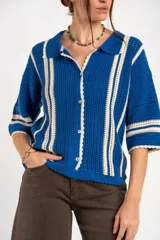 Cardigan oversize de crochet de algodón peinado, color azul con rayas verticales blancas, cuello tipo polo y cierre frontal de botones.