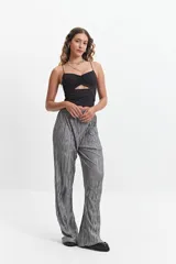 Top negro de tirantes finos con diseño de escote fruncido y abertura cut-out triangular en el centro del pecho. Confeccionado en tejido elástico, presenta un corte ajustado al cuerpo.