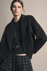 Blazer Zara de corte recto confeccionada en mezcla de lana, color gris oscuro. Presenta cuello con solapas de muesca, cierre frontal cruzado con botones y bolsillos delanteros con solapa.