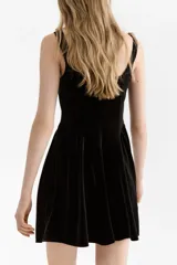 Vestido corto de velour negro con escote cuadrado, breteles anchos, cuerpo entallado y falda acampanada con frunces en la cadera.
