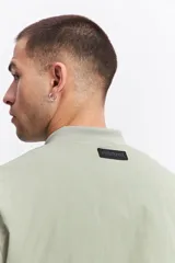 Campera tipo bomber de nylon color verde oliva, con cierre frontal, cuello, puños y cintura elastizados.