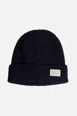 Gorro tipo beanie de punto acanalado en color verde oscuro, con vuelta en el borde y etiqueta rectangular con logo de la marca en la parte frontal.
