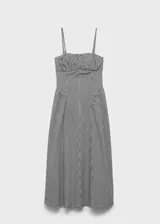 Vestido midi de corte evasé con estampado de cuadros vichy en blanco y negro. Presenta un diseño sin mangas con tirantes finos ajustables, escote recto con detalle fruncido y cierre de cremallera lateral.