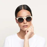 Lentes de sol Kubu modelo Willsi Carbon, con montura redonda de carey crema y lentes negros polarizados.