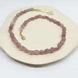 Collar de cuentas irregulares de cuarzo rosa con dije central de corazón de cuarzo rosa y herrajes con baño de oro.