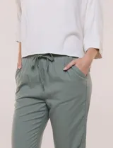 Pantalón de algodón color beige de corte recto, con pretina elastizada, cordón de ajuste y bolsillos laterales.