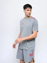 Remera deportiva Umbro negra de manga corta, con cuello redondo y tres franjas blancas en los hombros.