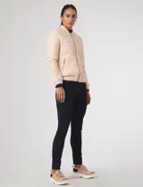 Campera bomber capitoneada color rosa pastel, con diseño acolchado en chevrón, cuello mao, cierre frontal y bolsillos laterales con tiradores metálicos circulares.