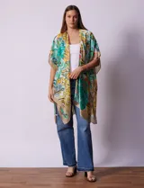 Kimono de satén con estampado tropical y hojas en tonos verdes, amarillos y naranjas sobre fondo claro. Tiene mangas anchas y corte abierto.
