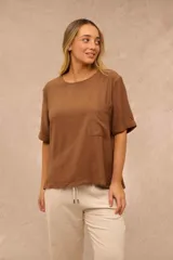Blusa marrón de corte holgado, con cuello redondo, mangas cortas con vuelta y un bolsillo aplicado en el pecho.