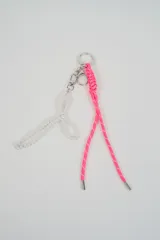 Llavero de diseño combinado con argolla metálica, que incluye un colgante de cordón trenzado fucsia con herrajes plateados y un colgante en forma de moño confeccionado con perlas sintéticas ensartadas.
