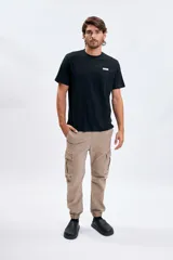 Pantalón cargo tipo jogger color tostado, de corte relaxed con bolsillos laterales con solapa en las piernas y puños elásticos en los tobillos.